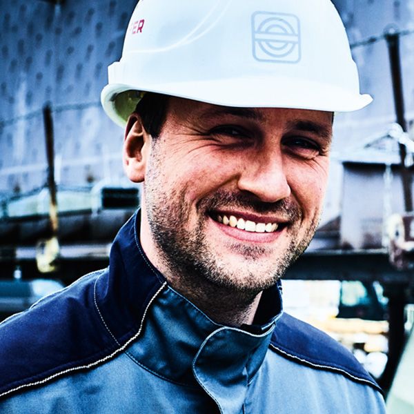 Portrait eines lächelnden Mannes mit weißem Helm