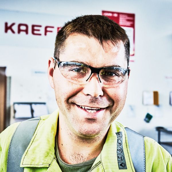 Portrait eines lächelnden Mannes mit Schutzbrille