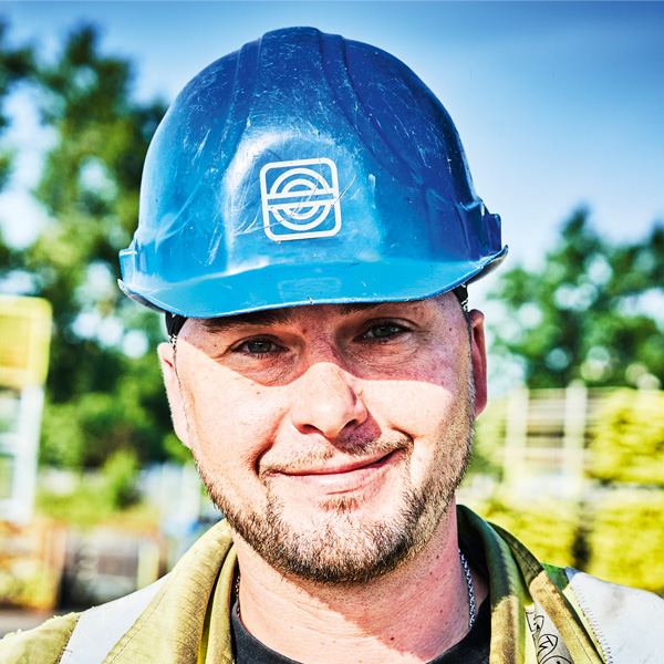 Ein lächelnder Mann mit blauem Helm